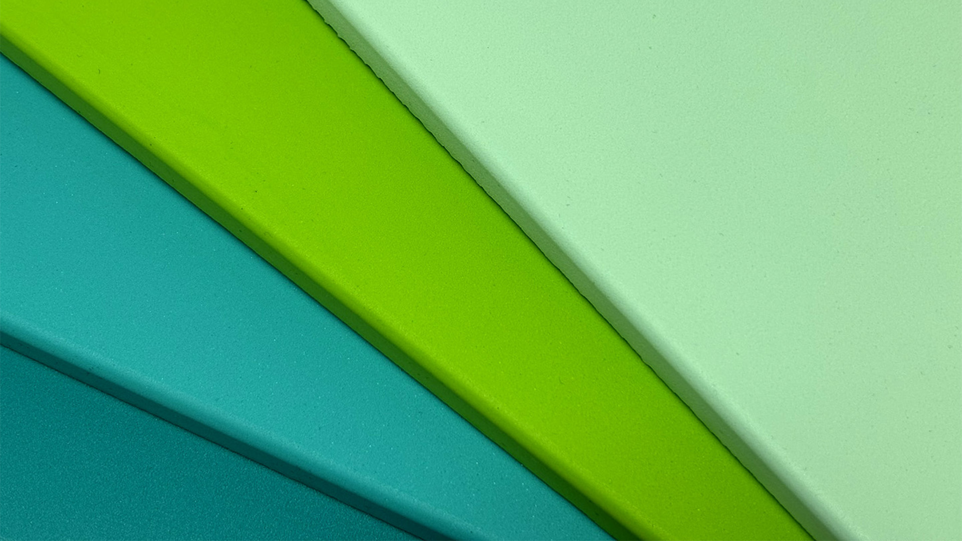Slabs of INSITE Levation poured polyurethane insole foam in dark teal, light teal, lime green, and sea foam green.